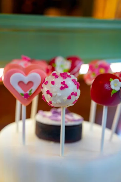 Food styling in bakery, wedding or happy valentine colorful lollypop candies decorated with chocolate hearts and flowers