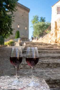 Tasting of red wine by old maker in Pierres Dores region with yellow stone houses on south of Beaujolais region, France, wine appelation region