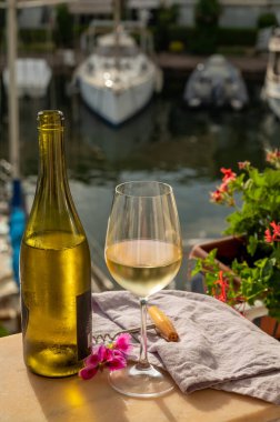 Port Grimaud 'un yat limanında manzaralı soğuk beyaz şarap içmek, Fransa' nın Provence şehrinde Fransız Rivierası 'nda yaz tatili