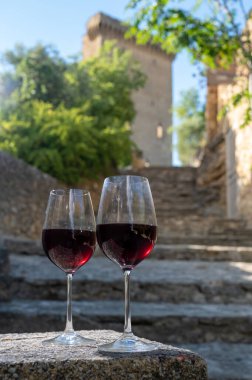 Tasting of red wine by old wine maker in Pierres Dores region with yellow stone houses on south of Beaujolais region, France, wine appelation