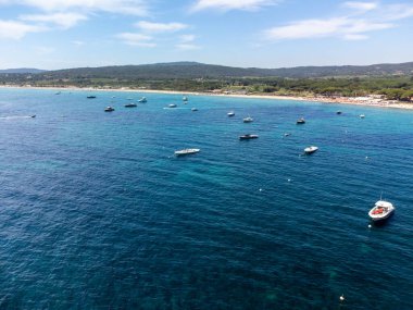 Saint-Tropez yakınlarındaki efsanevi Pampelonne plajı ve mavi deniz manzarası Fransız Rivierası 'nın beyaz kumlu sahillerinde yaz tatili.