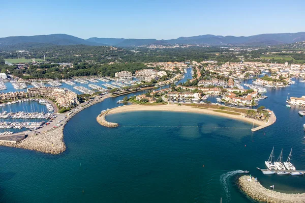 Aerial view on blue water of Gulf of Saint-Tropez, sail boats, houses of Port Grimaud and Port Cogolin, summer vacation in Provence, France