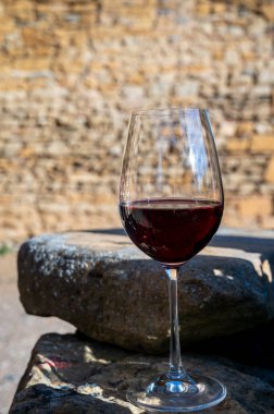 Tasting of red wine by old wine maker in Pierres Dores region with yellow stone houses on south of Beaujolais region, France, wine appelation