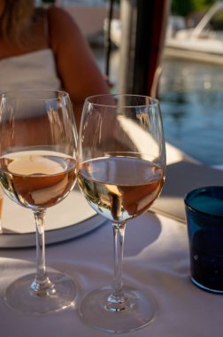 Dinner at sunset in French gourmet restaurant with cold dry rose wine in Port Grimaud, summer vacation on French Riviera, France