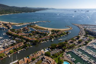 Aerial view on blue water of Gulf of Saint-Tropez, sail boats, houses of Port Grimaud and Port Cogolin, summer vacation in Provence, France
