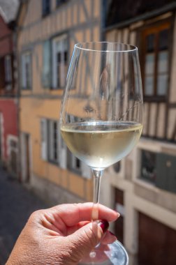 Tasting of white grand cru classe chablis wine with old French houses on background, Burgundy, wine tour is France