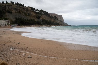 Denizde fırtına, Cassis, Provence, Fransa 'daki sarı kumlu sahilde yüksek dalgalar.
