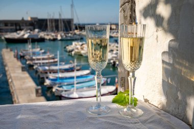 Yazın doğum günü kutlaması iki bardak Fransız şampanyası köpüklü şarap ve renkli balıkçı tekneleriyle Cassis, Provence, Fransa 'daki eski limanda.
