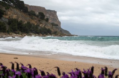 Denizde fırtına, Cassis, Provence, Fransa 'daki sarı kumlu sahilde yüksek dalgalar.
