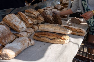 Doğal mayayla yapılan ekşi hamurlu biyolojik ekmek ve Provence, Fransa 'da pazarda satılmak üzere odun sobasında pişirildi.