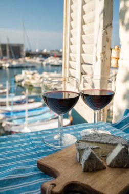 Kırmızı Provencal şarabı ve peynirli yaz partisi terasta eski balıkçıların limanı manzaralı Cassis, Provence, Fransa 'da renkli teknelerle