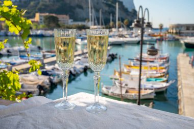 Yazın doğum günü kutlaması iki bardak Fransız şampanyası köpüklü şarap ve renkli balıkçı tekneleriyle Cassis, Provence, Fransa 'daki eski limanda.