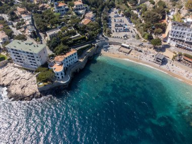 Kumsalda panoramik hava manzarası, mavi deniz, uçurumlar, evler, sokaklar ve Cassis, Provence, Fransa 'da deniz feneri olan eski balıkçıların limanı bulutlu bir günde