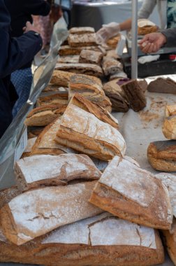 Doğal mayayla yapılan ekşi hamurlu biyolojik ekmek ve Provence, Fransa 'da pazarda satılmak üzere odun sobasında pişirildi.