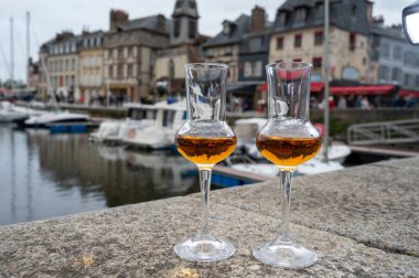 Eski Honfleur limanında elma sosu tadarken arka planda tekneler ve eski evler, Normandiya, Fransa
