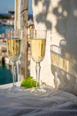 Yazın doğum günü kutlaması iki bardak Fransız şampanyası köpüklü şarap ve renkli balıkçı tekneleriyle Cassis, Provence, Fransa 'daki eski limanda.