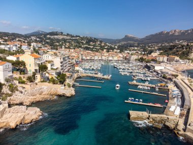 Kumsalda panoramik hava manzarası, mavi deniz, uçurumlar, evler, sokaklar ve Cassis, Provence, Fransa 'da deniz feneri olan eski balıkçıların limanı bulutlu bir günde
