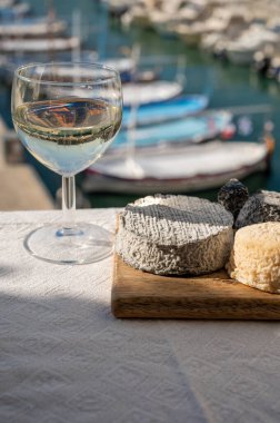 Fransız keçi peyniri crottin ve selles-sur-cher Cassis, Provence, Fransa 'nın limanındaki teknelerde sunuldu. Peynir, bir bardak kuru beyaz şarapla tattı.