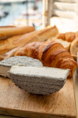 Fransız keçi peyniri selles-sur-cher ve taze kruvasan Cassis, Provence, Fransa 'nın limanındaki teknelerde servis ediliyor. Peynir tatma, yakın çekim.