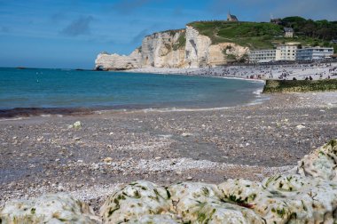 Alçak gelgit dönemi ve okyanusun dibindeki beyaz taşların manzarası ve Fransa 'nın Normandiya eyaletindeki Porte d' Aval kemerinin tebeşir kayalıkları. Turistler için tatil yeri.