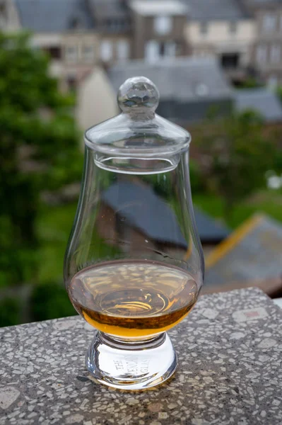 Dram of scotch whiskey with view on old houses on background, Edinburgh whisky tasting tour, Scotland
