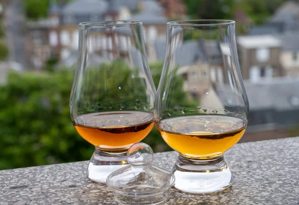 Two drams of scotch whiskey with view on old houses on background, Edinburgh whisky tasting tour, Scotland