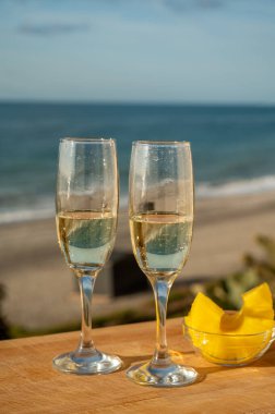 Güneşli bir günde İspanyol Cava şarabı, ananas ve mavi deniz manzaralı açık hava kahvaltısı ve Marbella 'da kumlu plaj, Costa del Sol tatil beldesi, Endülüs, İspanya