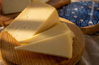 Spanish hard manchego, cow, sheep and goat cheese served outdoor in morning sunlights close up