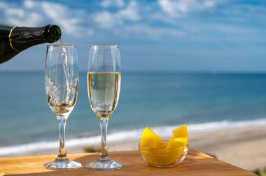 Güneşli bir günde İspanyol Cava şarabı, ananas ve mavi deniz manzaralı açık hava kahvaltısı ve Marbella 'da kumlu plaj, Costa del Sol tatil beldesi, Endülüs, İspanya