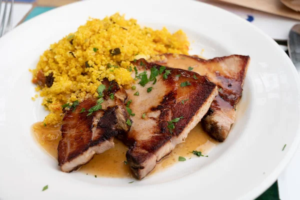 Andalusian cuisine, spicy cous-cous with grilled pork ham filet, Spanish food