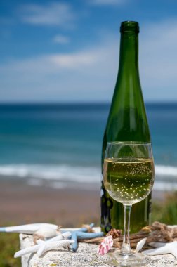 Cheeses of Normandy, round camembert cow cheese from Camembert village and heartshaped neufchatel from Neufchtel en Bray and view on alebaster cliffs Porte d'Aval in Etretat, Normandy, France