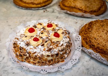 Kremalı ve kavrulmuş badem fıstıklı kek San Sebastian City, Bask Bölgesi, İspanya 'da zanaat fırınında sergileniyor.
