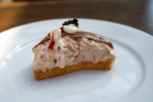 Typical snack in bars of Basque Country and Navarre, pinchos or pinxtos, small slices of bread upon which topping or mixture of toppings is placed, tuna fish pincho, San Sebastian, Spain