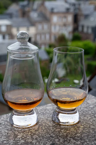 Two drams of scotch whiskey with view on old houses on background, Edinburgh whisky tasting tour, Scotland