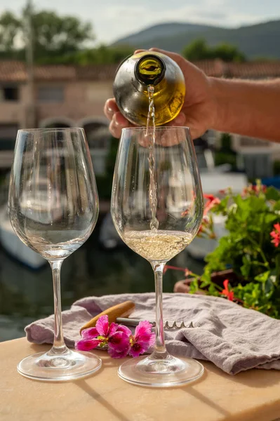 Port Grimaud limanında bir yat limanında soğuk beyaz şarap bardakları doldurmak, Fransa 'nın Provence şehrinde Fransız Riviera' sında yaz tatili