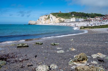 Alçak gelgit dönemi ve okyanusun dibindeki beyaz taşların manzarası ve Fransa 'nın Normandiya eyaletindeki Porte d' Aval kemerinin tebeşir kayalıkları. Turistler için tatil yeri.