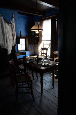 Old fashioned wooden chairs and table in sunlights by window, Dutch interior and room decoration in rich fisherman's house in North-Holland, Enkhuizen, Netherlands