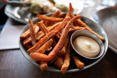 Bowl with tasty deep fried sweet potato chips served with mayonnaise sauce