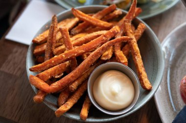 Bowl with tasty deep fried sweet potato chips served with mayonnaise sauce