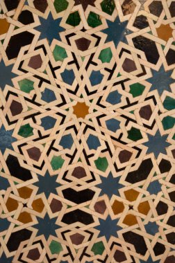 İspanya, Endülüs 'teki Alhambra Sarayı Granada' daki Nasrid Sarayı 'ndaki duvarların süslü ortaçağ seramik fayansları. Arapça süsleme arkaplan duvar kağıdı.