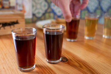 Tasting of different sweet wines from wooden barrels on old bodega wine bar in central part of Malaga, Andalusia, Spain