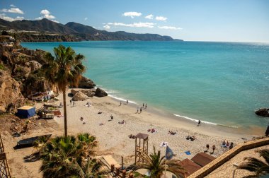 Seyahat yeri, kumlu sahil manzarası, mavi deniz ve dağlar Endülüs 'ün küçük bir kasabası olan Nerja' daki Balcon de Europa 'dan ilkbaharda Costa del Sol, İspanya' da beyaz evleri ve dar sokakları olan