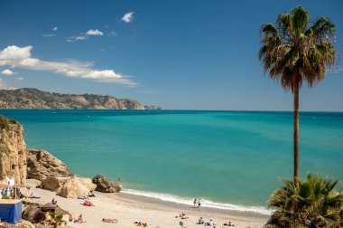 Seyahat yeri, kumlu sahil manzarası, mavi deniz ve dağlar Endülüs 'ün küçük bir kasabası olan Nerja' daki Balcon de Europa 'dan ilkbaharda Costa del Sol, İspanya' da beyaz evleri ve dar sokakları olan
