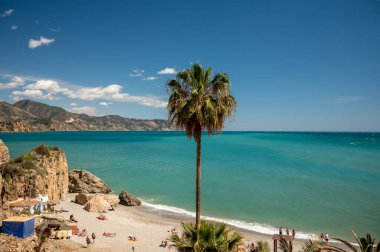 Seyahat yeri, kumlu sahil manzarası, mavi deniz ve dağlar Endülüs 'ün küçük bir kasabası olan Nerja' daki Balcon de Europa 'dan ilkbaharda Costa del Sol, İspanya' da beyaz evleri ve dar sokakları olan