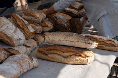 Doğal mayayla yapılan ekşi hamurlu biyolojik ekmek ve Provence, Fransa 'da pazarda satılmak üzere odun sobasında pişirildi.
