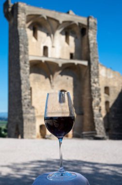 Tasting of red wine by old wine maker in Pierres Dores region with yellow stone houses on south of Beaujolais region France, wine appellation region
