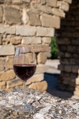 Tasting of red wine by old wine maker in Pierres Dores region with yellow stone houses on south of Beaujolais region France, wine appellation region