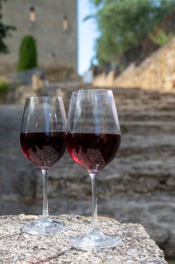 Tasting of red wine by old wine maker in Pierres Dores region with yellow stone houses on south of Beaujolais region France, wine appellation region