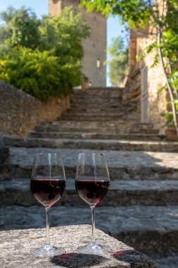 Tasting of red wine by old wine maker in Pierres Dores region with yellow stone houses on south of Beaujolais region France, wine appellation region