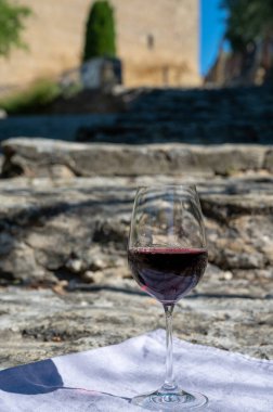 Tasting of red wine by old wine maker in Pierres Dores region with yellow stone houses on south of Beaujolais region France, wine appellation region